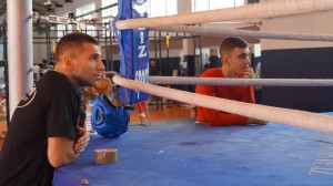 El preprador de boxeo de Bilbao Igor Cabezas y el boxeador de Bilbao Jon Fernández siguen las evoluciones de un compañero sobre el ring durante un entrenamiento.